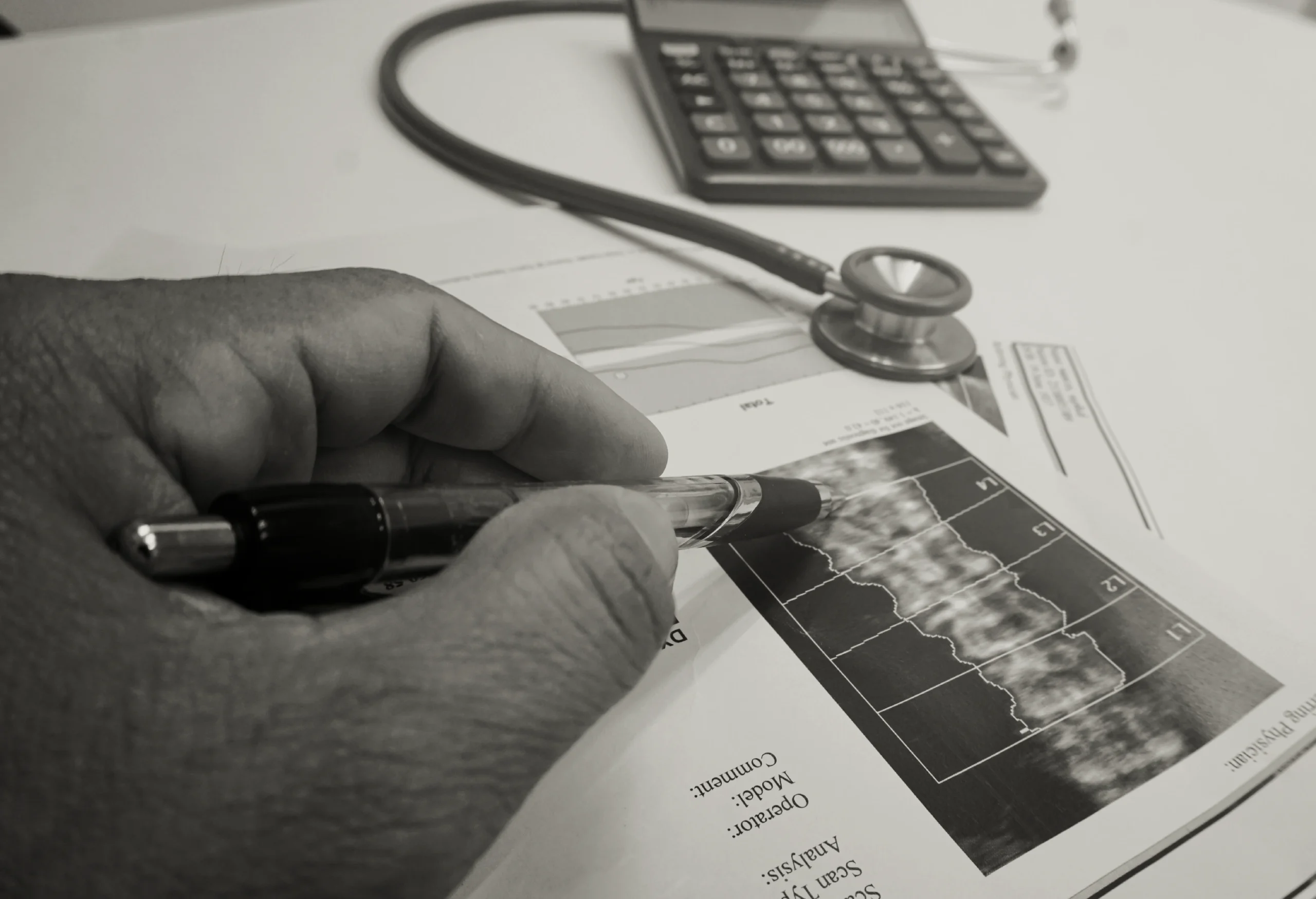 Close-up of a stethoscope and paperwork on a desk.