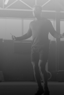 A person jumps rope in a gym or training space during a fitness workout.